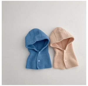 Detail of baby knitted balaclava hood with buttons in blue and beige colors