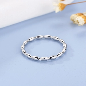 Detailed view of silver stainless steel minimalist beaded ring on a fresh blue background
