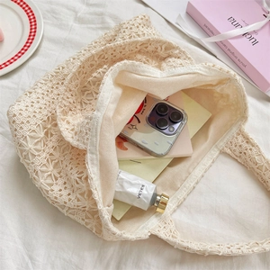 Close-up of beige lace tote bag showing interior lining and daily essentials storage