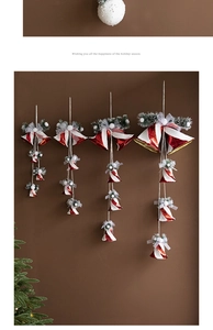 Detail of red and white Christmas bell ornaments with gold trim and pine needle accents
