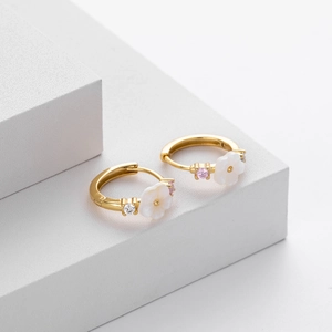 Detail view of S925 silver gold hoop earrings featuring white flowers and pink zircons