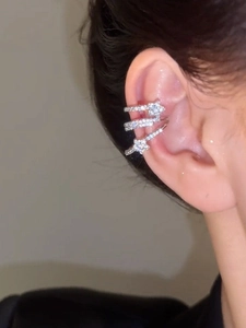 Detail of silver multi-layer spiral ear cuff with zircon stars on woman's ear