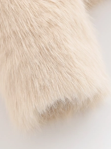 Close-up of fluffy apricot faux fur texture showing soft plush long-hair fabric details