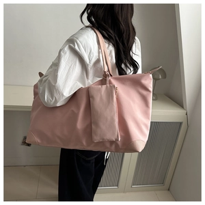 Pink waterproof nylon tote bag detail with matching hanging pouch and leather corners