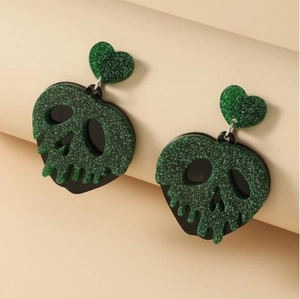 Boucles d'oreilles tête de mort Halloween avec cœurs pailletés verts sur fond neutre