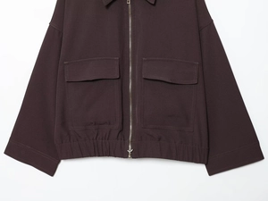 Détail de la veste utilitaire marron foncé avec grandes poches à rabat et zip en métal
