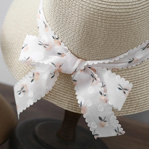 Straw sun hat with peach-patterned chiffon bow and wide brim for beach vacations