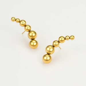 Detailed shot of curved gold titanium earrings featuring graduated spheres with metallic finish