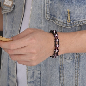 Detail of purple and black bike chain bracelet with inset zircons on male wrist
