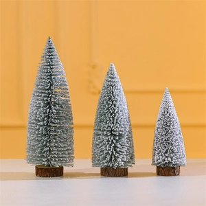 Three mini flocked Christmas trees with natural wood bases in various sizes for table decor