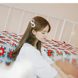 Detail of beige marble resin hair clip in figure 8 shape on wavy hair