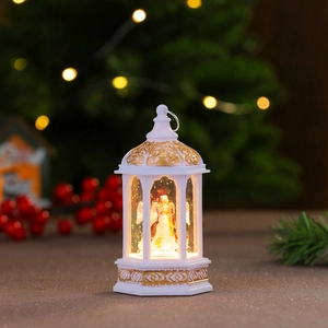 Close-up of white Christmas lantern with angel sculpture inside and gold hollow patterns