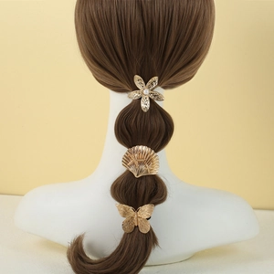 Golden metal hair ring set with floral, shell and butterfly charms on brown ponytail