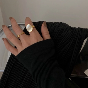 Close-up of a gold-plated ring set featuring a large oval mother of pearl inlay on hand