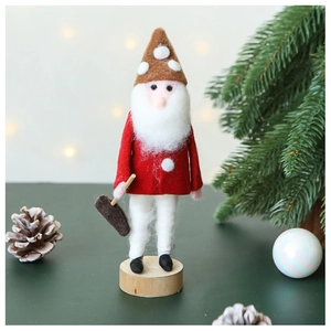 Detail of wool felt Christmas gnome ornament with red coat and polka dot hat on wood base