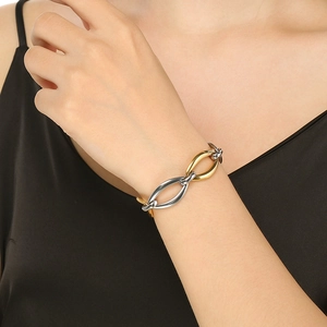 Detail of two-tone gold and silver interlocking link bracelet on a female wrist