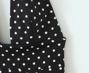 Détail de robe noire à pois blancs montrant la texture du tissu et les coutures nettes