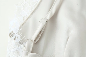 Detailed close-up of adjustable strap and lace trim on a satin dress