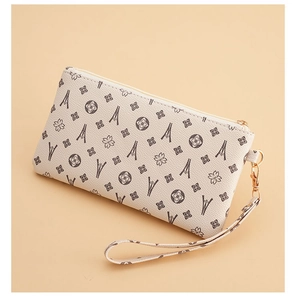 Detail of beige faux leather clutch with Eiffel Tower print and gold zipper pull