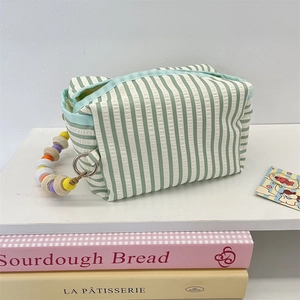 Detail of green striped fabric tissue organizer with colorful bead chain handle
