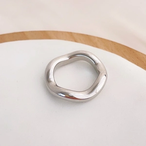 Close-up of a silver wavy stainless steel ring with irregular minimalist design