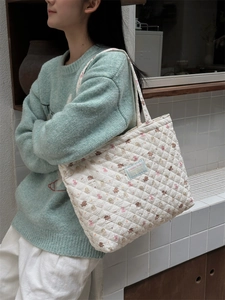 Quilted tote bag detail featuring animal prints and diamond stitching on shoulder