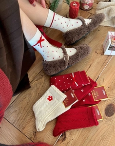 Close-up of festive red Christmas socks with bows on a vintage wooden background