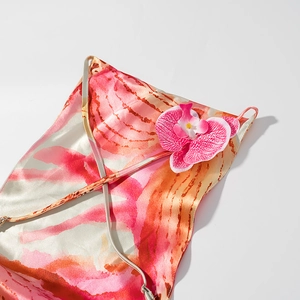 Dettaglio del vestito in raso floreale con orchidea 3D e stampa acquerello rosa arancio
