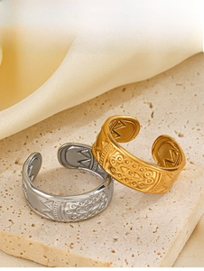 Detailed macro view of vintage gold and silver adjustable rings on beige stone surface