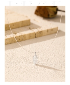 Macro detail of marquise-cut moissanite pendant on a transparent invisible fishing line necklace