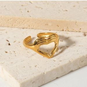 Detail of gold heart-shaped ring on stone showing polished finish and open design