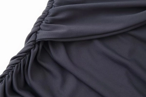 Gros plan détaillé des fronces latérales sur une robe licou gris foncé moulante