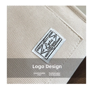 Close-up of beige corduroy fabric texture and premium stitched brand label on small square bag