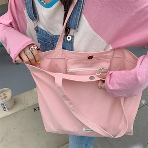 Detail of pink canvas tote bag featuring a spacious interior and a secure zipper pocket