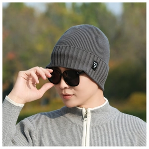 Close-up of dark grey knitted beanie with ribbed texture and black logo patch detail