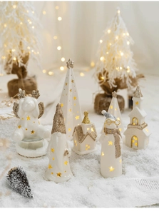 Close-up of glowing white ceramic Christmas ornaments with warm LED lights and gold glitter