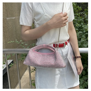 Detailed close-up of a pink rhinestone evening handbag with a silver metal chain strap