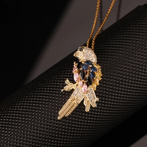 Macro shot of bird pendant with colorful zircons and golden metal texture detail