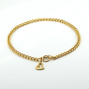 Golden stainless steel Cuban chain necklace with heart pendant and OT clasp on white background