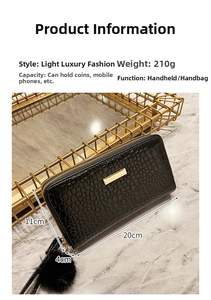 Detail shot of black crocodile embossed long wallet with gold metal bar and dimensions