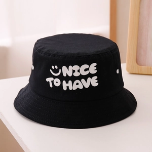 Détail du chapeau bob noir en coton avec texte blanc NICE TO HAVE et motif smiley brodé