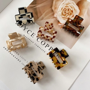 Detail shot of square acetate hair claws in checkerboard and marble patterns