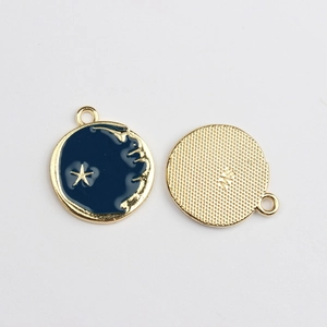 Detail of round star moon enamel pendants showing blue finish and gold texture back