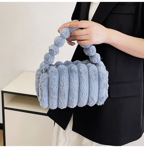 Detailed view of blue plush handbag featuring bubble handles and quilted fluffy texture