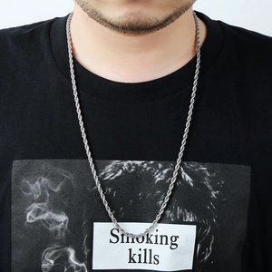 Close-up of a silver stainless steel rope chain necklace on a model wearing a black shirt