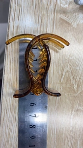 Detailed size measurement of the 5cm amber plastic claw clip on a ruler for scale