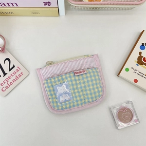 Detailed view of quilted checkered coin purse with transparent card slot and zipper
