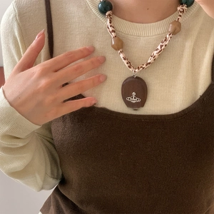 Macro shot of leopard print fabric cord necklace with resin beads and saturn pendant