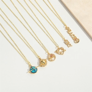 Detailed flat lay of golden necklaces featuring Mama and Peace charms with zircon accents