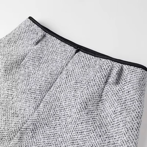 Macro view of the black and white herringbone tweed fabric with an invisible zipper detail